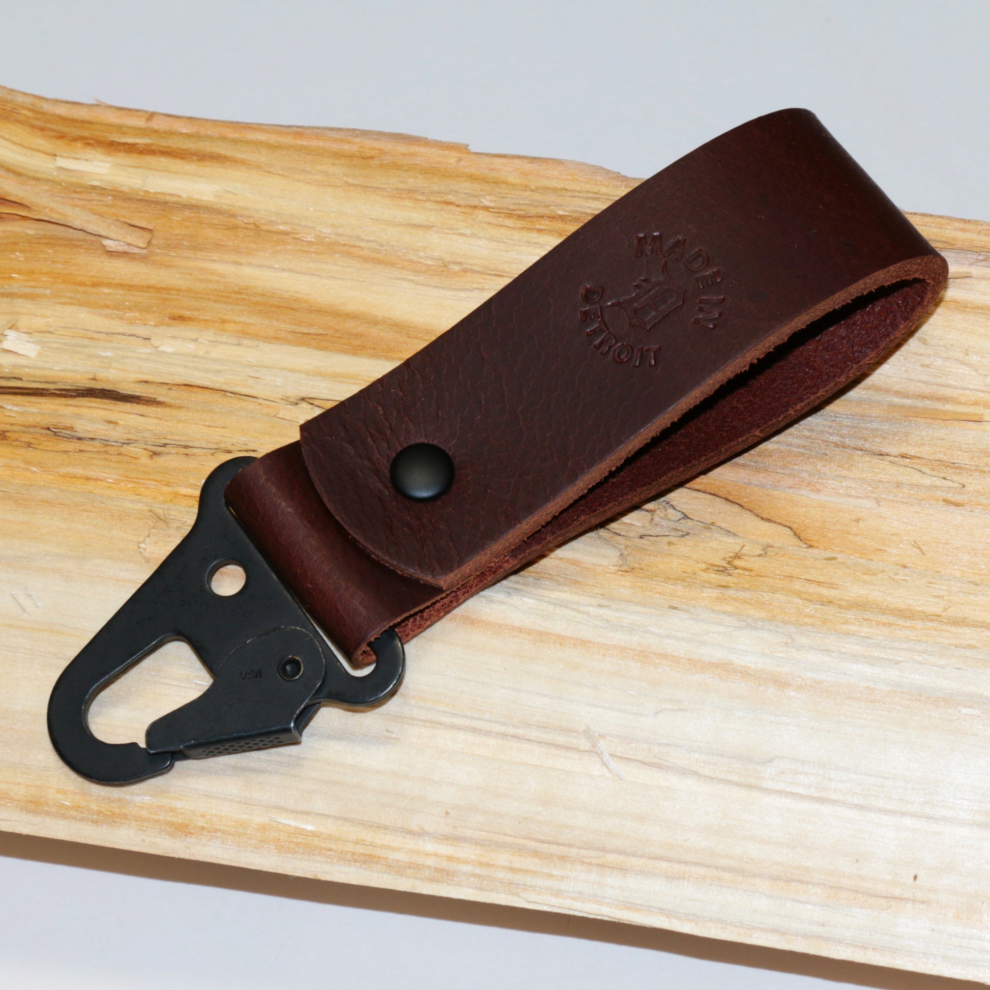 Brown leather keychain with HK style snaphook on a wooden background